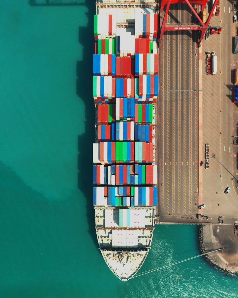 Container ship at dock. ScripDeal connects exporters to verified scrip buyers